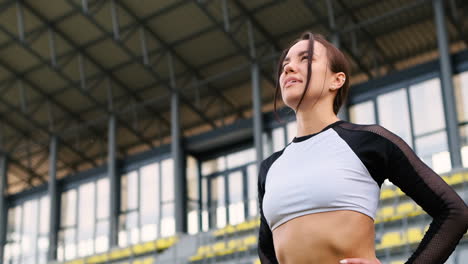 tired beautiful woman resting after running workout in the stadium