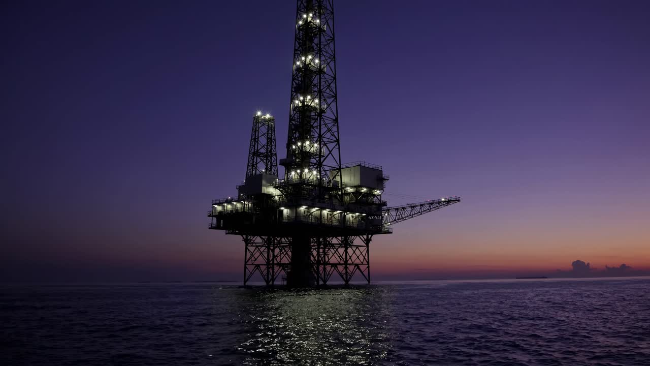 Illuminated Offshore Oil Rig at Twilight on the Open Sea