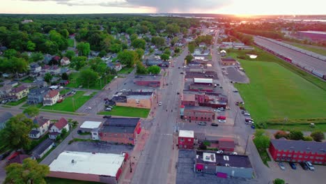 Aerial-view-of-Silvis,-Illinois,-showing-residential-and-commercial-areas,-roads,-and-greenery-during-sunset