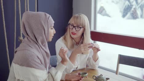 dos mujeres disfrutando del té en un café