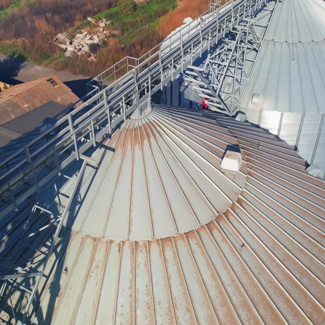 Aerial view of metal grain elevator in agricultural zone. Grain warehouse