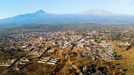 Sonnenaufgang-–-Kenia-Landschaft-Mit-Einem-Dorf,-Kilimandscharo-Und-Amboseli-Nationalpark-–-Verfolgung,-Drohnen-Luftaufnahme