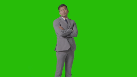 Three-Quarter-Length-Portrait-Of-Serious-Businessman-In-Suit-Folding-Arms-Against-Green-Screen-1