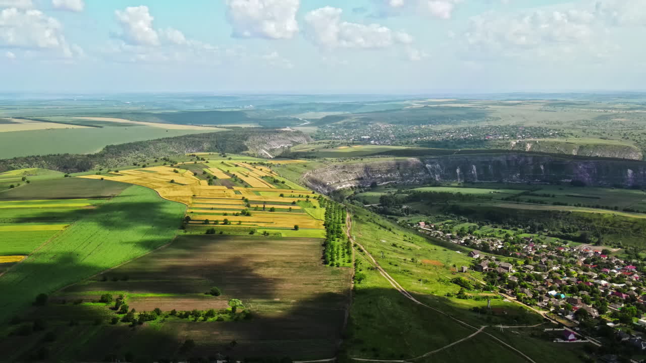 Aerial drone view of nature, valley with river and village, hills and fields, greenery, Moldova