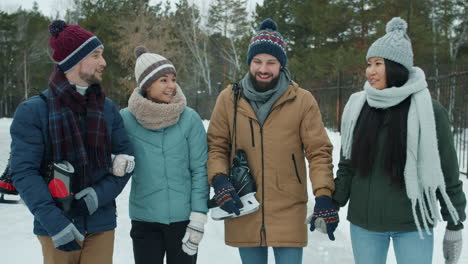 friends ice skating in winter park
