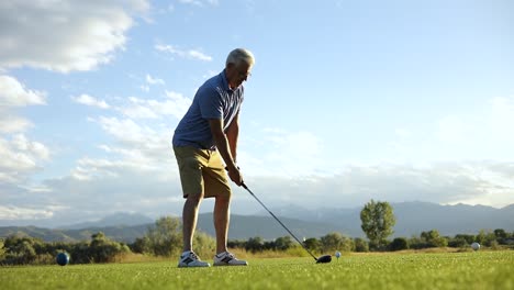 cinematic wide angle slow motion shot of a man about to drive a ball off of a teebox