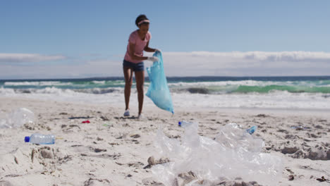 Mujer-Afroamericana-Recogiendo-Residuos-Plásticos-En-La-Playa.