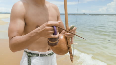 hombre sin camisa tocando un instrumento