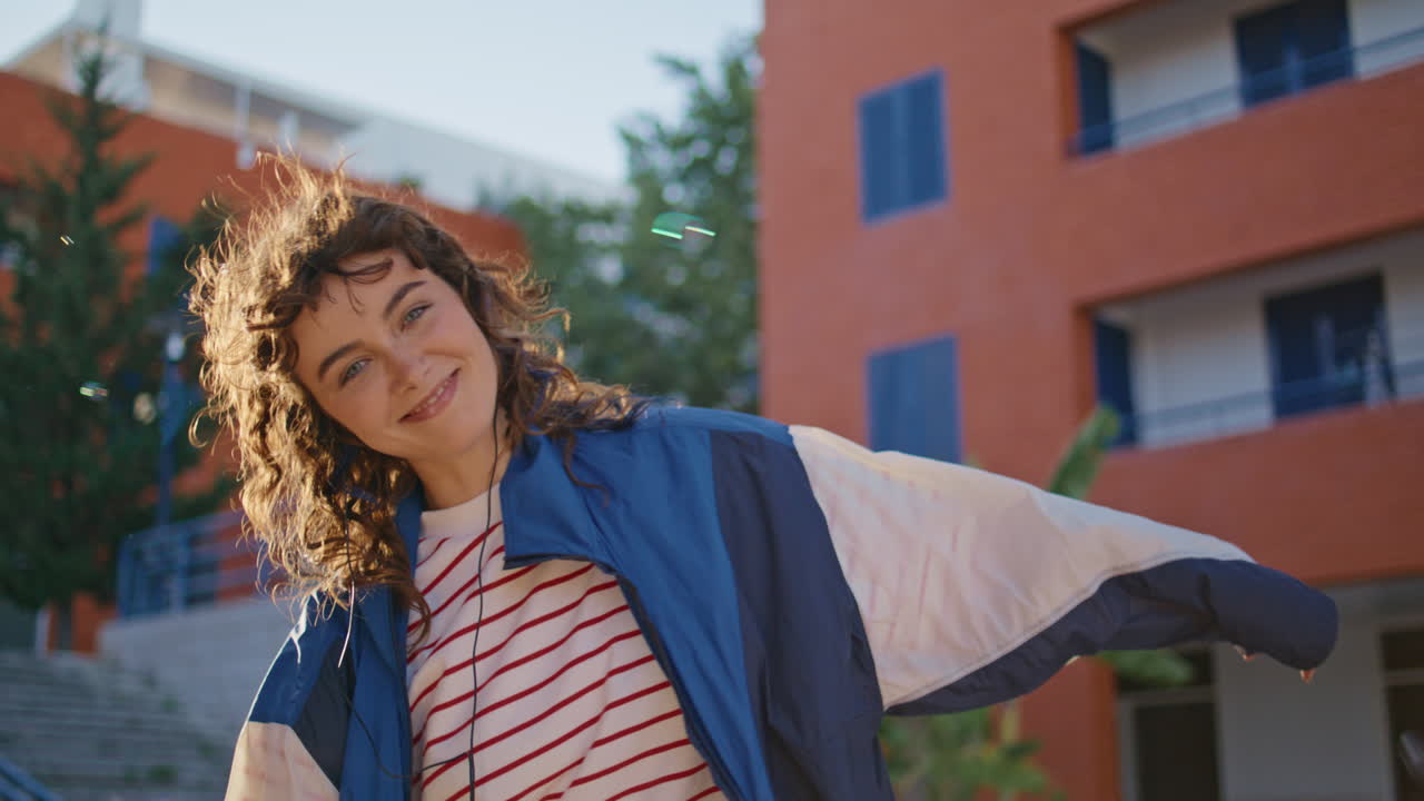 chica feliz bailando en la calle con auriculares de cerca. mujer escuchando música