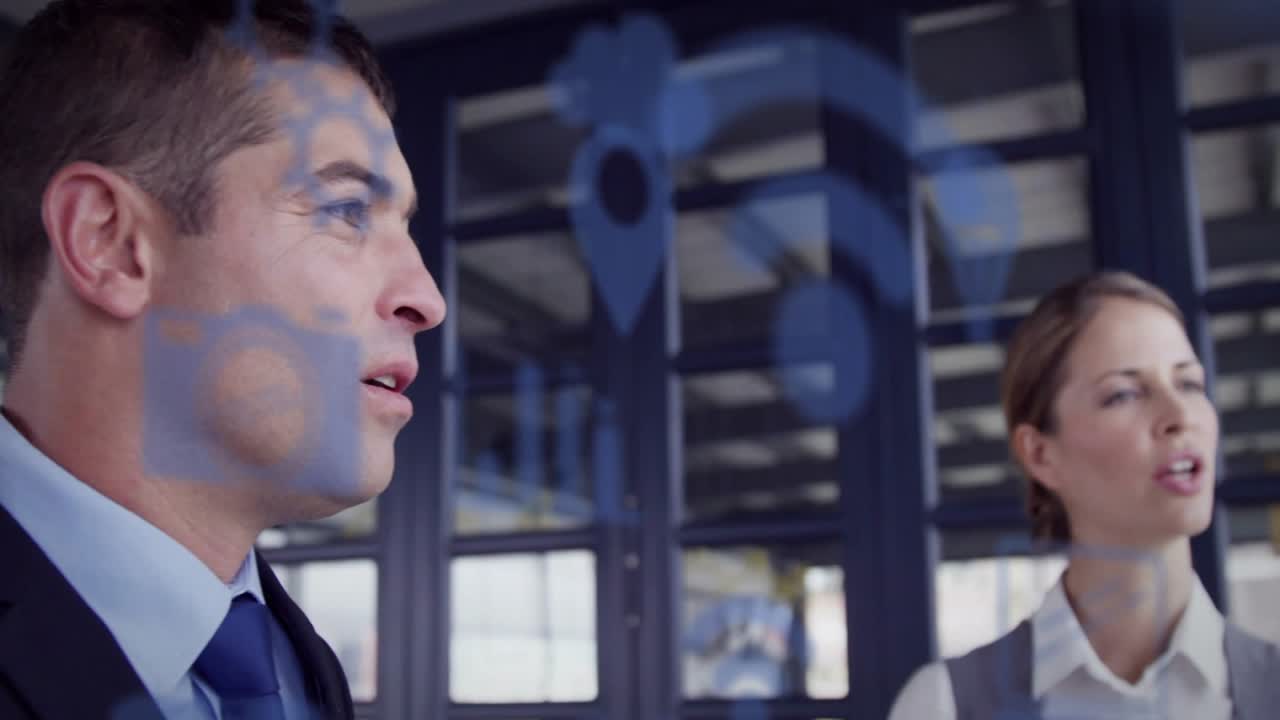Professionista uomo che presenta su una superficie di vetro, generando diagrammi blu, team che discute il piano aziendale