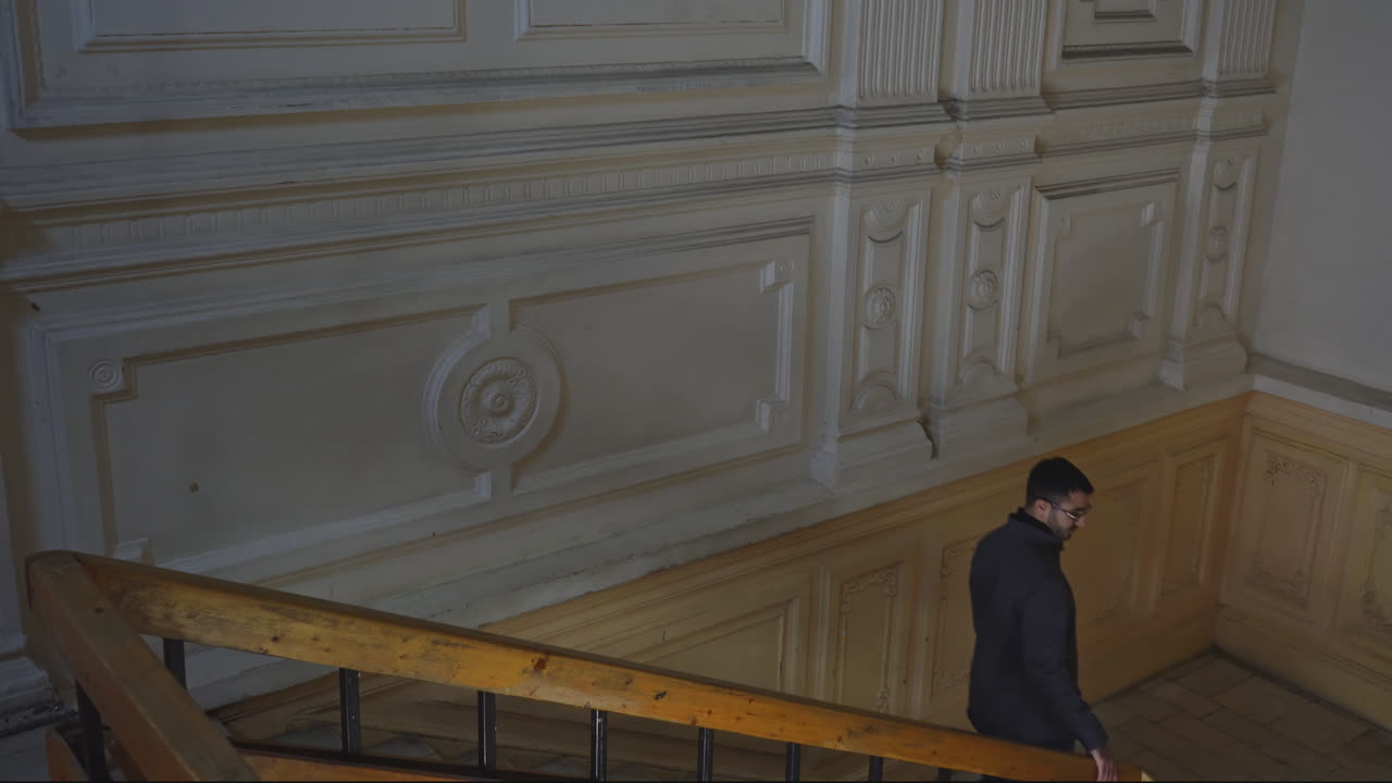 Man walking up the stairs in an old building