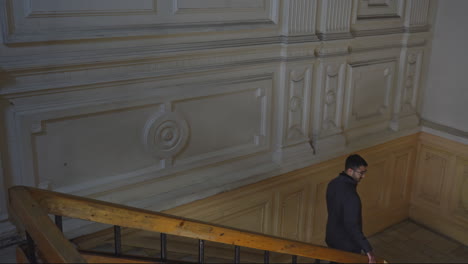 man walking up the stairs in an old building