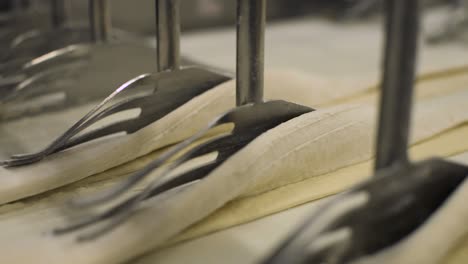 time lapse of folding raw pastry dough automatically by industrial automated machine inside a bread factory