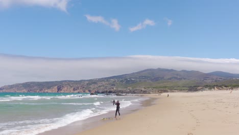 A-Windsurfer-Adjusting-his-Windsail-and-Getting-Ready-to-get-into-the-Water-at-Praia-do-Guincho,-Portugal