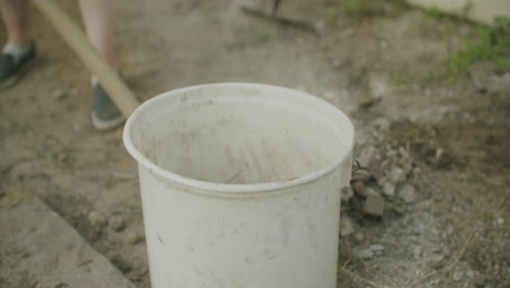 fotografía de mano de una hembra usando una pala para recoger la suciedad