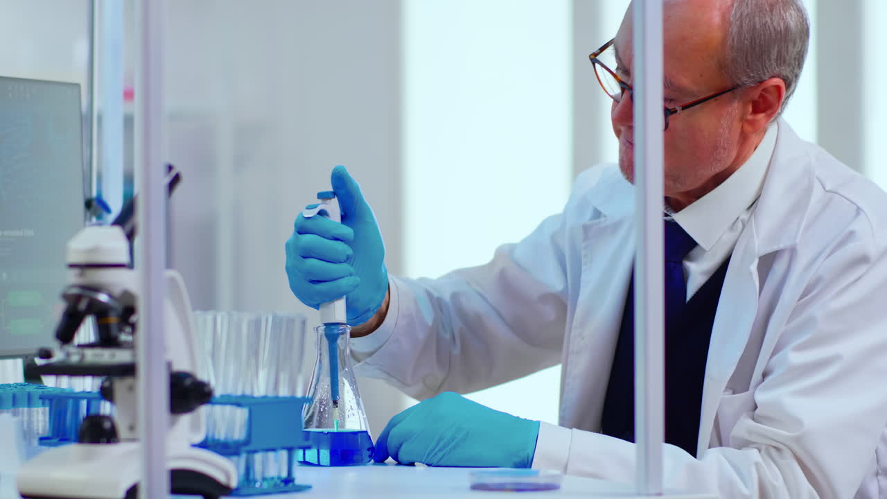 Laboratory senior man scientist working with test tubes and a pipette
