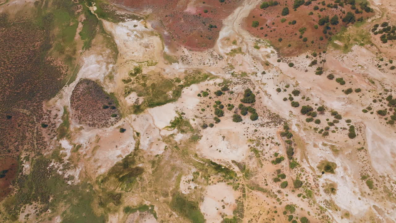 Dry landscape with no vegetation and little moss and lichen. Many colors combining in the soil. Aerial perspective.