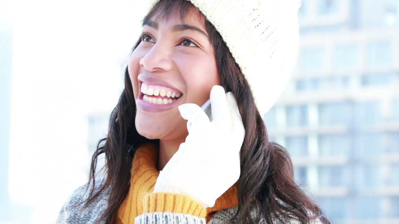 따뜻한 옷을 입은 여성이 전화하고 있습니다.