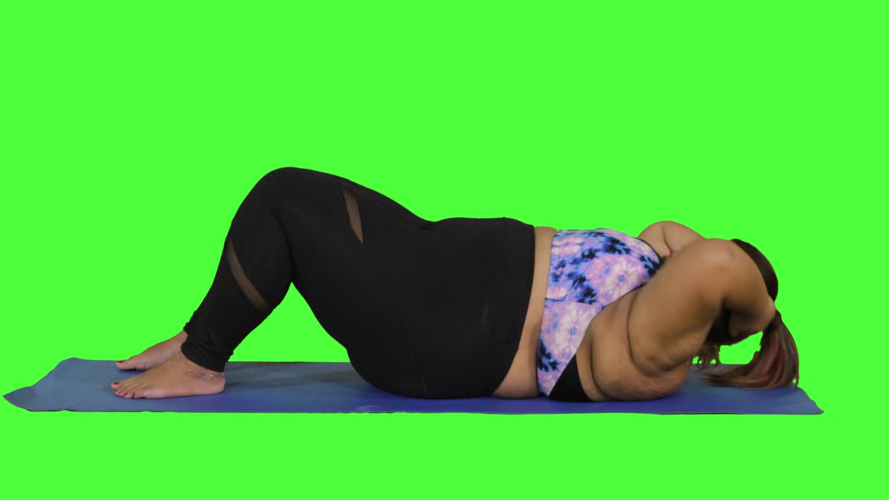 mujer con sobrepeso haciendo abdominales en el estudio