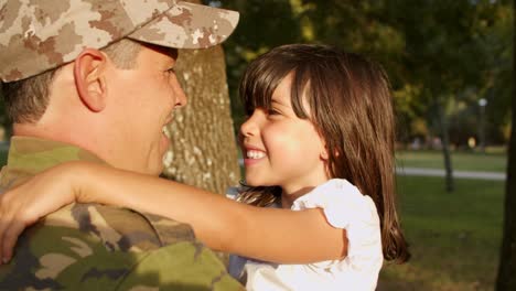 glücklicher militärvater, der kleine tochter in den armen hält