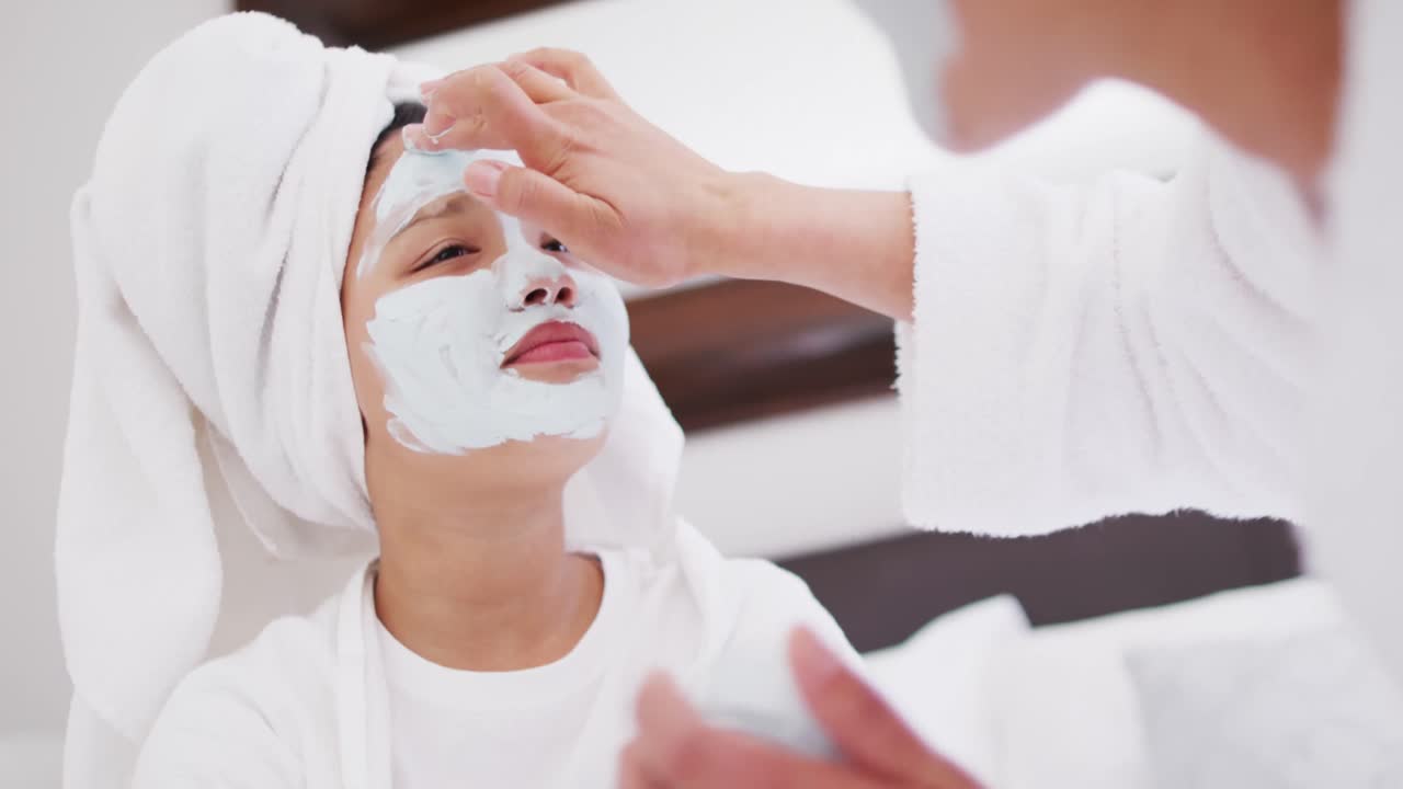 복장을 입은 행복한 아시아 어머니와 딸의 비디오는 얼굴에 수분을 공급하고 재미를 느끼고 있습니다.