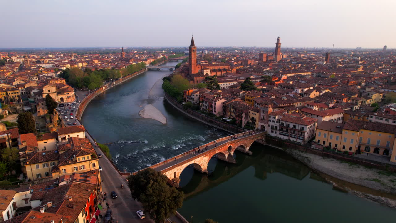 Verona picturesque old town by the river at sunset. Aerial tilt up