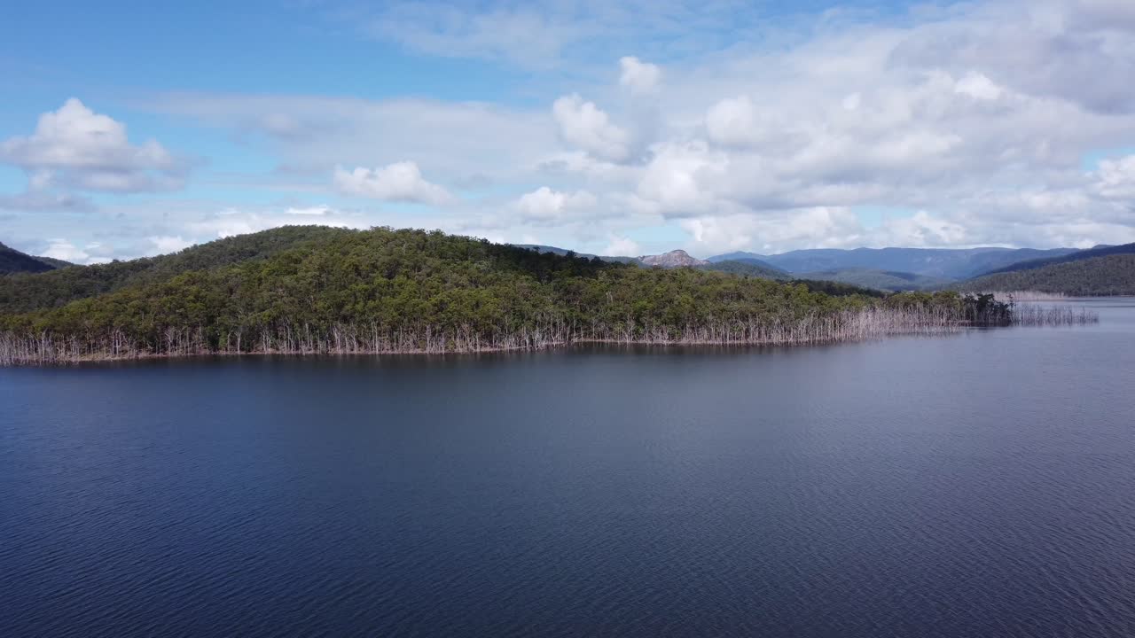 vuelo lento sobre el agua hacia una colina verde