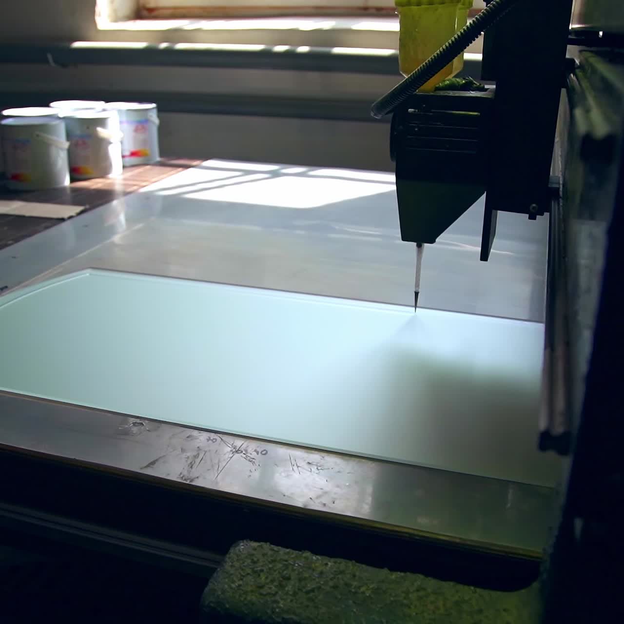 Big machine-tool making picture on the glass part of a door. Modern plant for doors producing