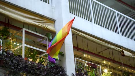 celebration of gay pride in singapore with rainbow flag hanging outside hdb building in chinatown , singapore