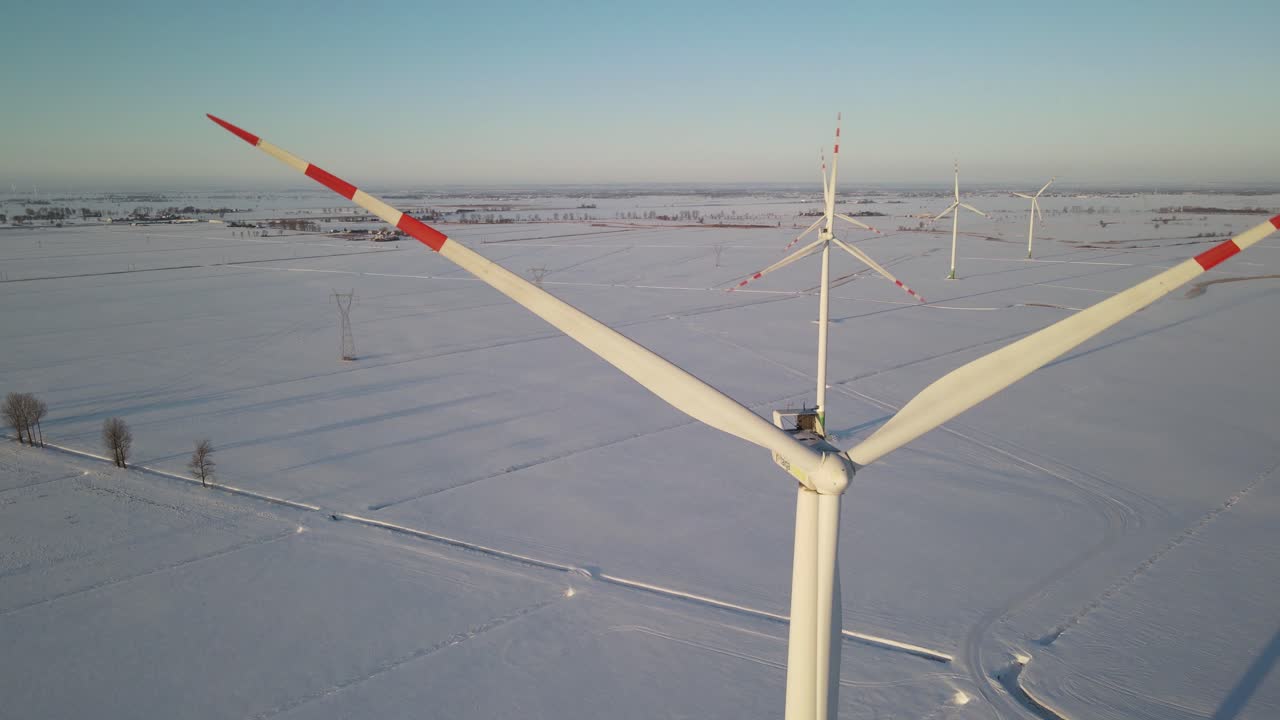 추운 겨울날 폴란드의 풍력 발전소에서 재생 에너지를 생산하는 풍력 터빈 높이에서 드론 보기