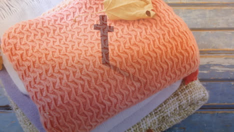 Stacked towels with cross pattern on wooden surface in animation style