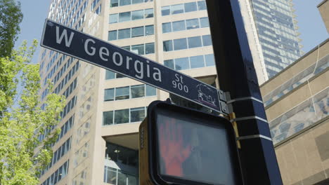 Straßenschild-Der-W-Georgia-Street-Und-Ein-Rotes-Schild-Für-Fußgänger-In-Vancouver,-Handheld,-Parallaxenbewegung