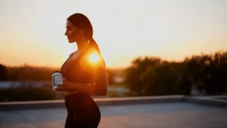 woman holding supplements at sunset