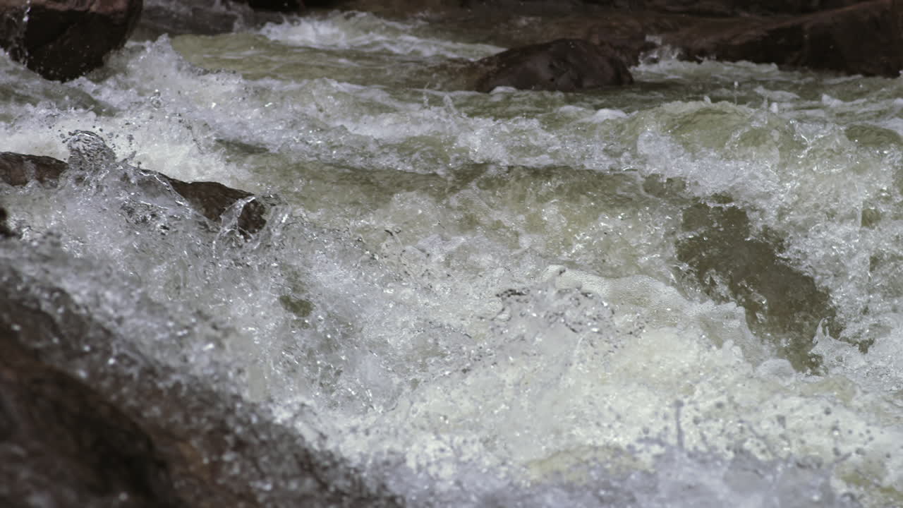 Super slow motion footage of white water rapids moving over the rocks of a creek in Chattanooga, TN.