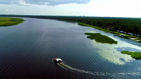 Aerial-drone-shot-over-large-barge-moving-along-large-river-while-passengers-partying-in-the-summer-day