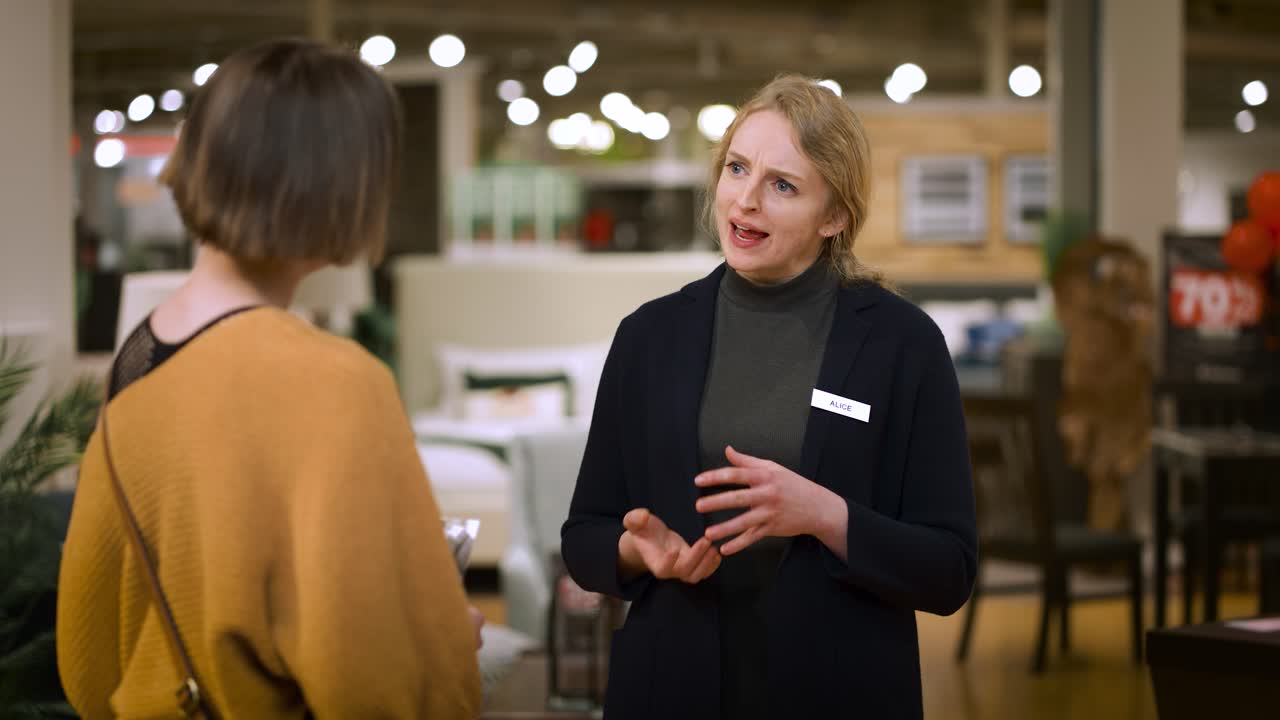 Smilende kvindelig sælger giver visitkort og takker kunde, der forlader butikken
