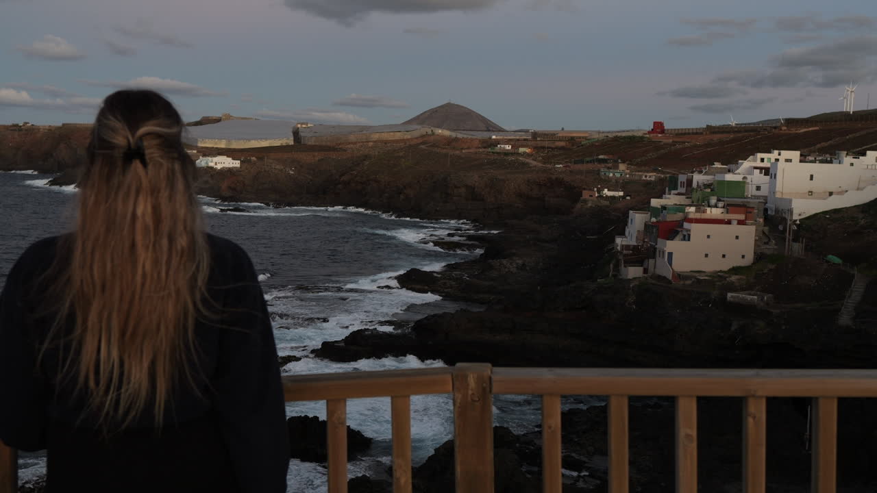 젊은 여성은 그란 카나리아 섬의 갈다르 시에 위치한 풍경과 절벽을 감상하며 일몰 동안