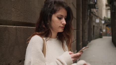 Mujer-Joven-Usando-Un-Teléfono-Inteligente-En-La-Calle