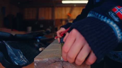 a man marks measurements on a wooden board in preparation for a pajero makeover - close up