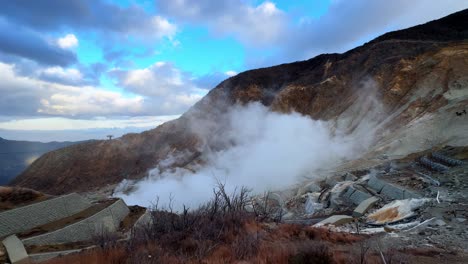 A steaming volcanic valley with rugged mountains and dramatic clouds in Owakudani Hakone