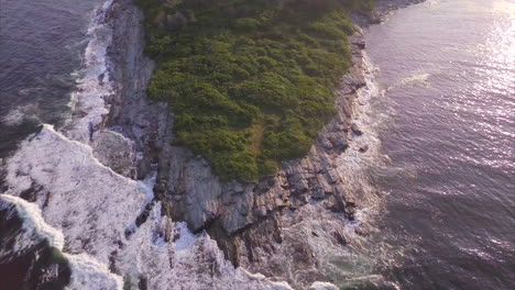 toma aérea flotando sobre las olas azul oscuro del océano atlántico chocando contra la isla de richmond frente a la costa de maine