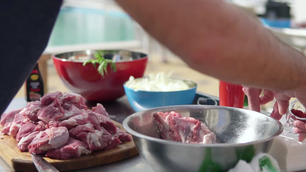 Person's hands preparing raw meat for cooking. The wooden surface outside. Barbeque time. shot in 4k