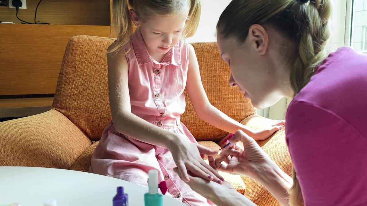 mãe e filha a pintar as unhas.