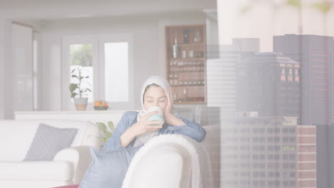 animation of cityscape over biracial woman in hijab drinking tea