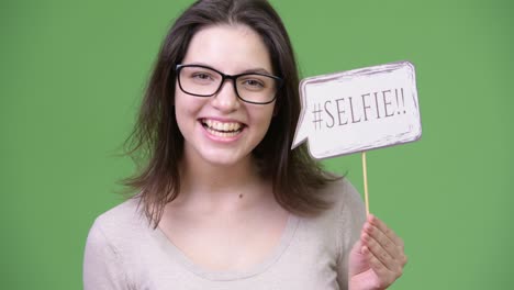 young beautiful woman shouting while holding selfie paper sign