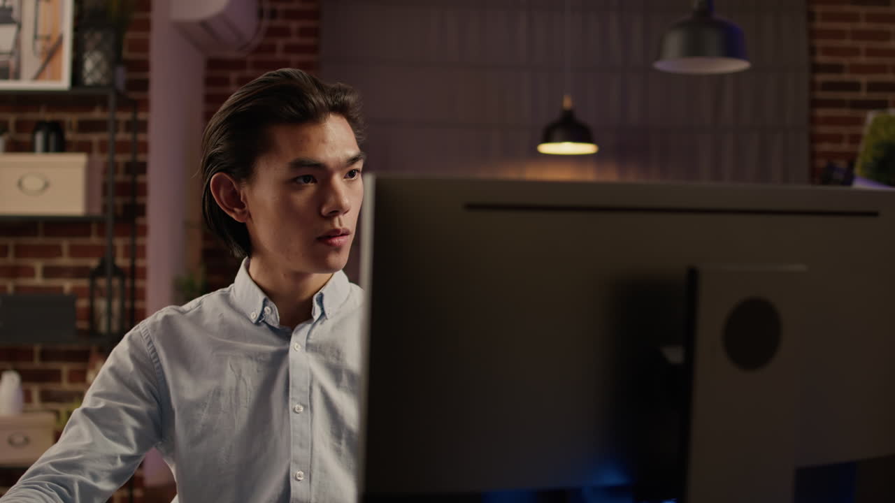 Asian man working on computer at night
