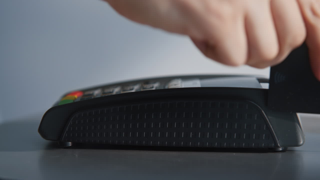 Closeup credit card machine money transaction. Woman hand swiping pos terminal