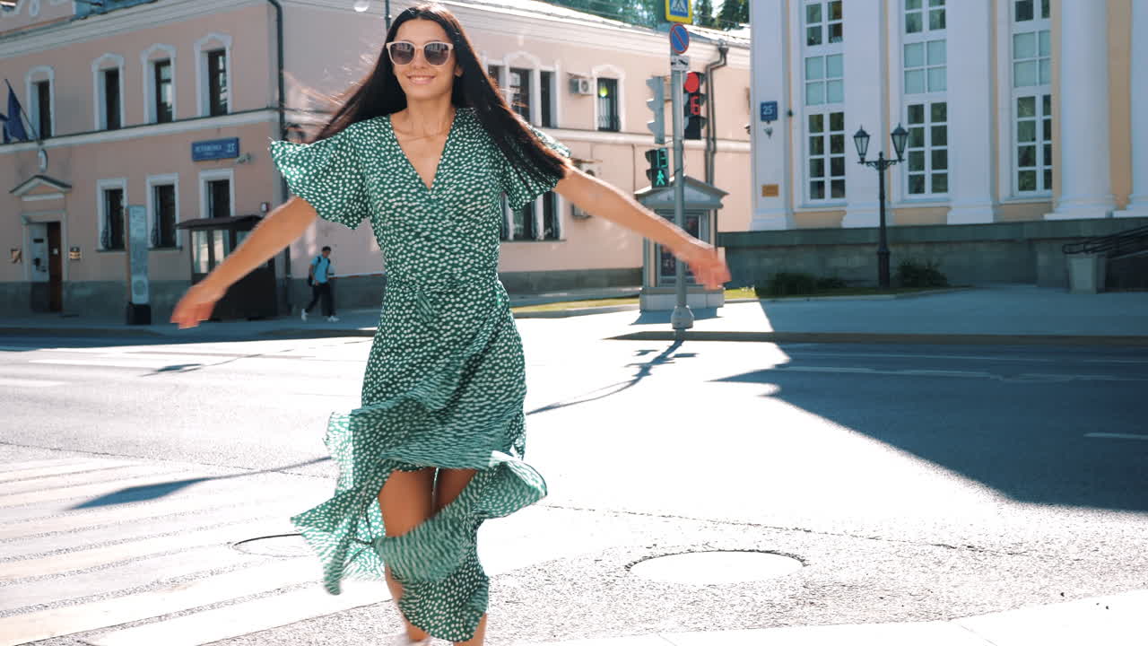 mujer de vestido verde caminando por la calle de la ciudad