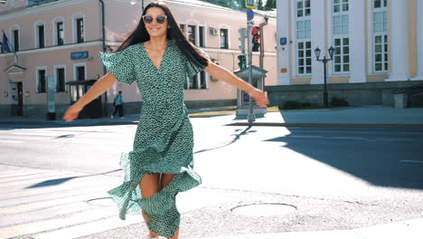 woman in green dress walking down city street