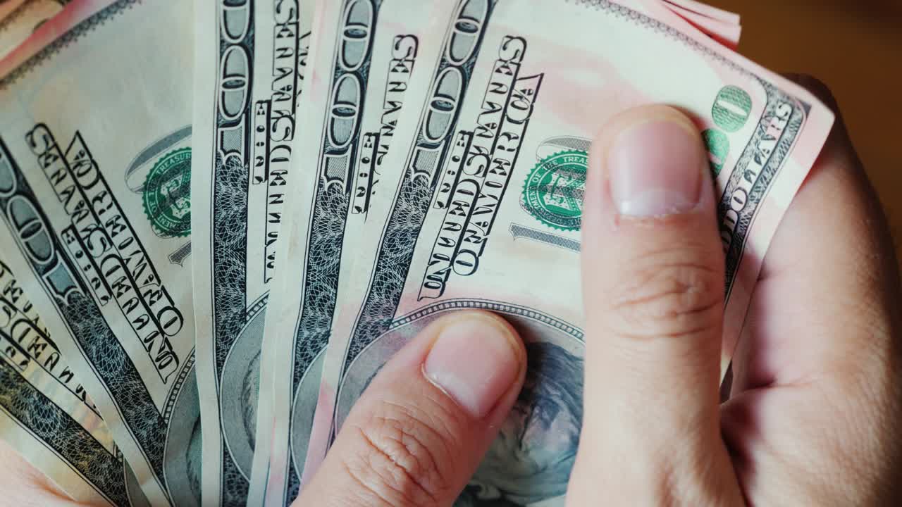 inspecciona cuidadosamente los billetes de 100 dólares. los billetes están teñidos de pintura rosa